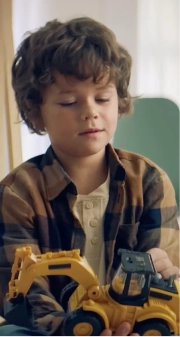 Young child playing with yellow toy bulldozer.